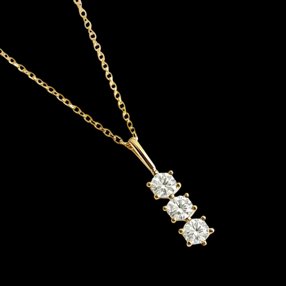 A golden-tone necklace with three clear round stones in a descending pendant.